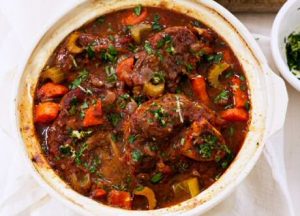 Zeer makkelijk osso bucco recept met kalfsschenkel, tomatenpulp, selder, wortel en porto, geserveerd met vers gehakte peterselie